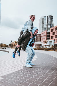 Man in Jacket Carrying Woman at Back thumbnail