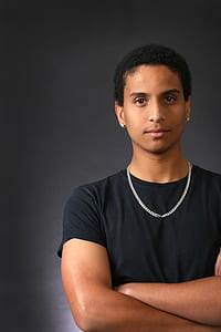 man in black crew-neck t-shirt with gold-colored chain necklace thumbnail