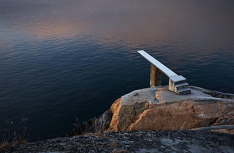 wooden dock on rock formation above body of water thumbnail