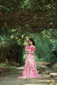 woman in pink floral off-shoulder dress under tree thumbnail