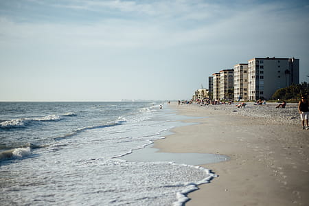 White Cloudy Sky over Seashore With Buildings during Daytime thumbnail