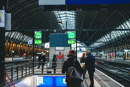 woman carrying black leather shoulder bag in train station thumbnail