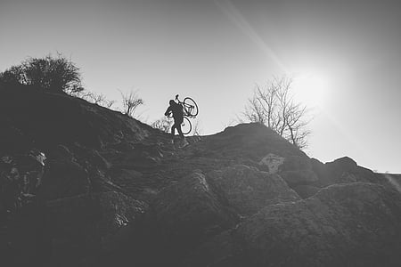 man carrying bike on top of mountain thumbnail