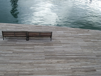 brown wooden bench near water during daytime thumbnail