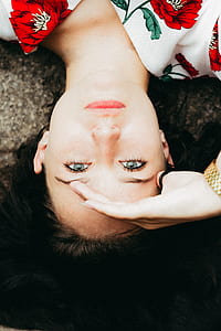 woman lying on gray concrete pavement while hand over the eyes taken at daytime thumbnail
