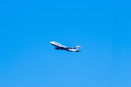 white commercial airplane on mid air under clear blue sky during daytime thumbnail