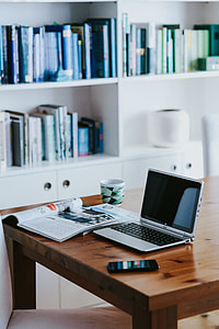 Silver laptop with various items on a table thumbnail