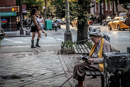 woman sitting on bench beside road thumbnail