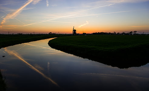 river between of grass field during orange sunset thumbnail