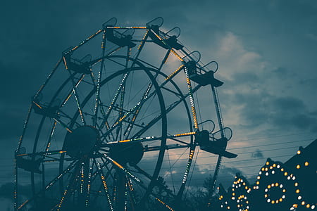 ferris wheel with lights turned on under cloudy sky thumbnail
