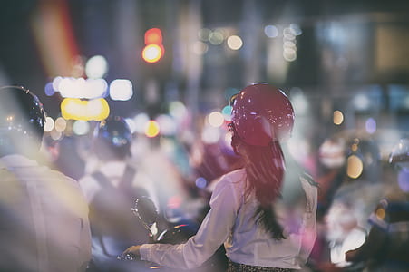 woman in brown jacket with red helmet on motorcycle selective-focus photography thumbnail