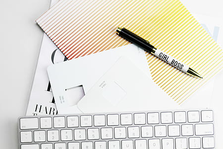 Apple Wireless Keyboard near black retractable pen on papers thumbnail