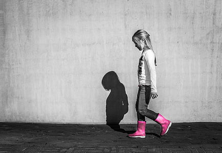 toddler in crew-neck shirt and pants standing near concrete wall thumbnail