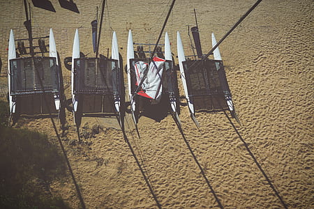white and black sail boat on beach thumbnail