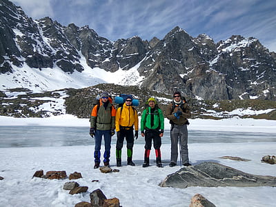 four man standing on covered ice mountain during daytime thumbnail