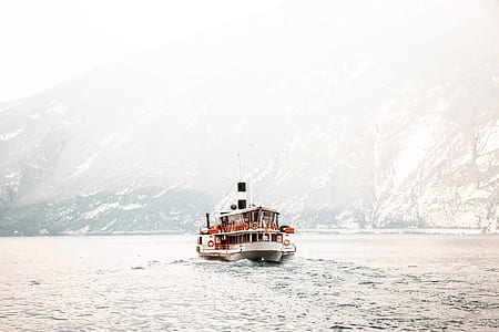 white and red motorboat near mountain thumbnail