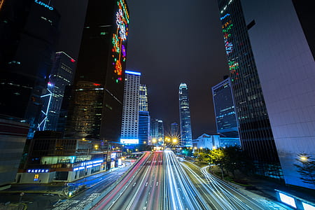 time lapsed photography of vehicles beside high-rise buildings during nighttime thumbnail