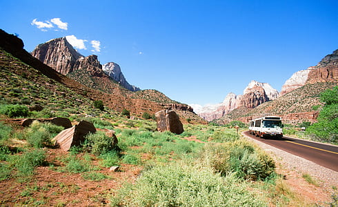 white vehicle on road between mountain during daytime thumbnail