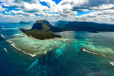 aerial view of island under cloudy sky thumbnail
