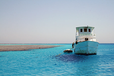 white boat sailing near land thumbnail