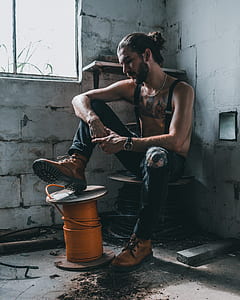 man sitting on the spool at the corner of the room thumbnail