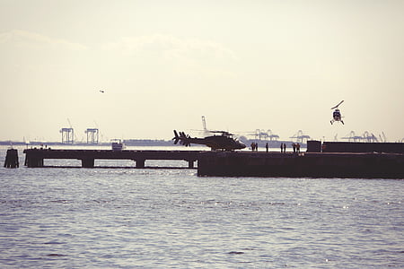 black helicopter on dock near sea thumbnail
