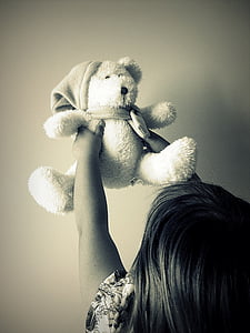 grayscale of toddler holding bear plush toy thumbnail
