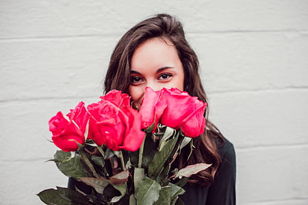 woman holding and red roses bouquet covering half of her face thumbnail