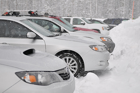 several cars parked on snow covered parking area thumbnail