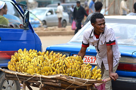 man pushing cart filled with bananas thumbnail