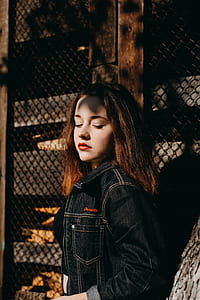 woman closing eyes near wall thumbnail