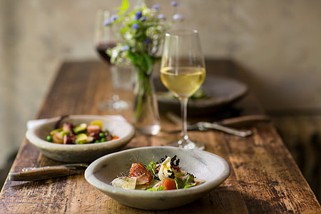 tilt shift photo of vegetables on round saucer beside glass of champagne on wooden tabletop thumbnail