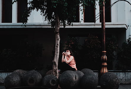 woman sitting on ball-shaped structure thumbnail
