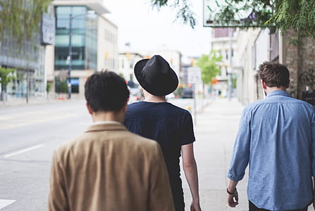 three men walking on sidewalk thumbnail