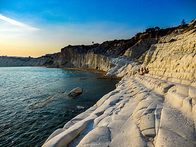 rippling body of water surrounded by rock formation thumbnail
