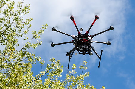 black and red drone near tree thumbnail