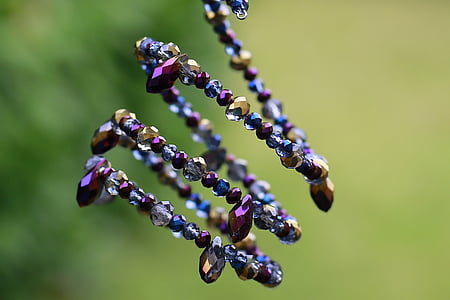selective focus photography of purple, grey, and gold-colored beaded bracelet thumbnail