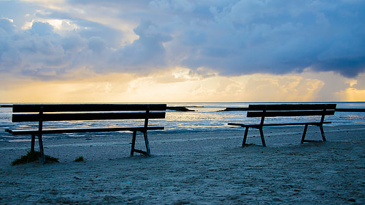 two brown wooden bench in front ocean wave during sunset thumbnail