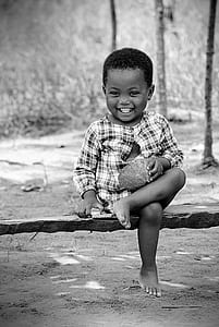kid sitting on wooden bench holding coconut shell thumbnail