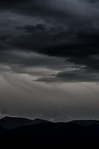 photography of mountain under black clouds thumbnail