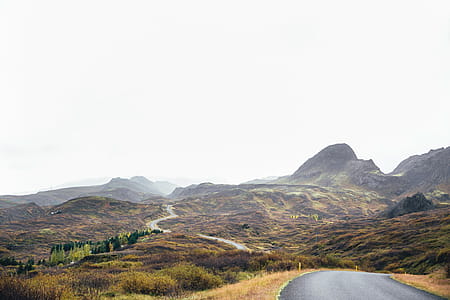 A winding road through moss-grown hills on a cloudy day thumbnail