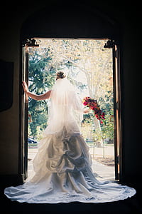 woman wearing wedding gown standing near doorway thumbnail