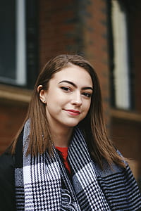woman standing near red brick building during daytime thumbnail