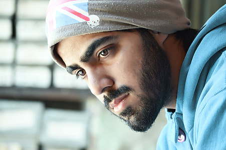 man wearing knit cap and teal top thumbnail