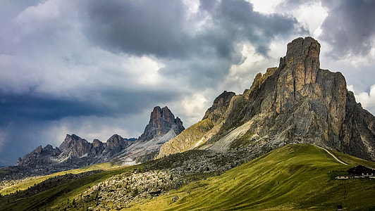 brown mountain with greenfield under cloudy sky photography thumbnail