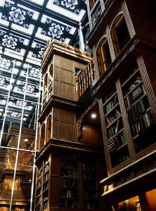 brown wooden bookshelf with books under glass roof thumbnail