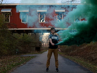 man holding smoke bottle on road thumbnail