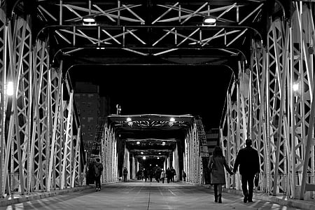 grayscale photo of people walks on steel bridge thumbnail