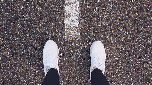 person wearing white sneakers taking photo thumbnail