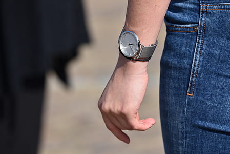 person wearing round silver-colored analog watch thumbnail